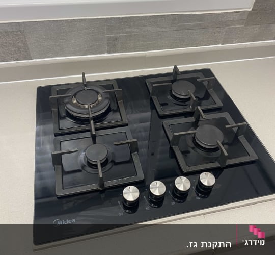 כיריים גז עם ארבעה מבערים וכפתורי שליטה